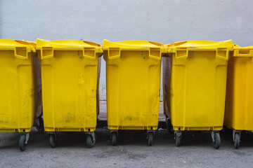 several yellow containers for recycling packaging on a street