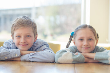 Smiling Boy and Girl Leaning on Table.