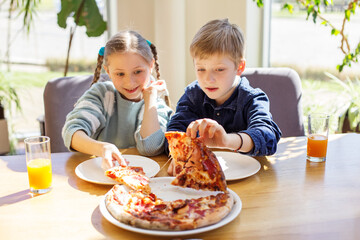 Siblings Enjoying Pizza Together During Lunch. Happy children