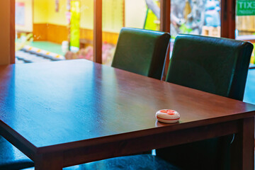 Pager device for ordering food on wooden table in restaurant. Wireless restaurant pager caregiver...