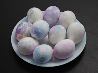 Hand painted with markers for drawing, decorated easter eggs on white plate.