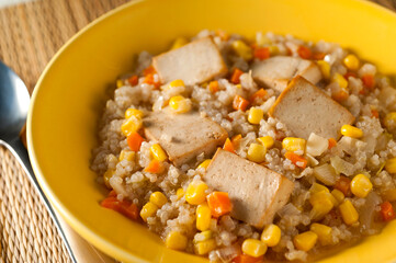 quinoa with tofu and sweet corn in a yellow bowl