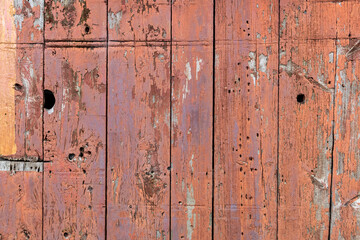 Abstract detail surface of an old, red, weathered wooden barn.