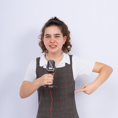 With microphone in hand positive teenage girl singer, young karaoke singer hold microphone.