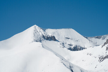 Peaks Kutelo 1 and 2 of the Pirin Mountains covered in snow were photographed from a distant slope with telephoto lens.