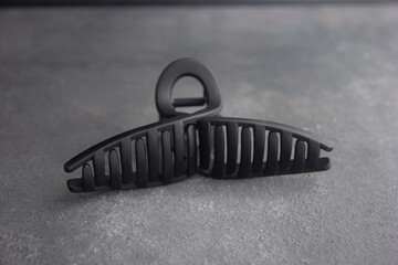 hair clip on isolated black background, close up of big black hair clip