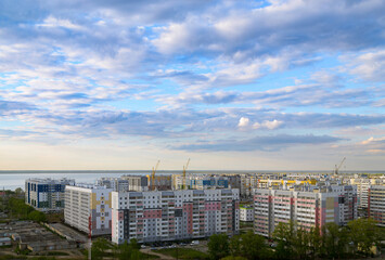 Top view of the city in the light of the sun under a cloudy sky at sunset - Powered by Adobe