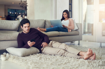 Couple, reading and relax in living room with phone, laptop and social media notification on mobile app in home. Man, woman and tech on carpet for streaming, care or chat on vacation on sofa in house