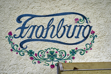 Lettering at apartment house with flower decoration and word Frohburg translation is happy castle...