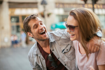 Happy couple shopping and laughing on city street