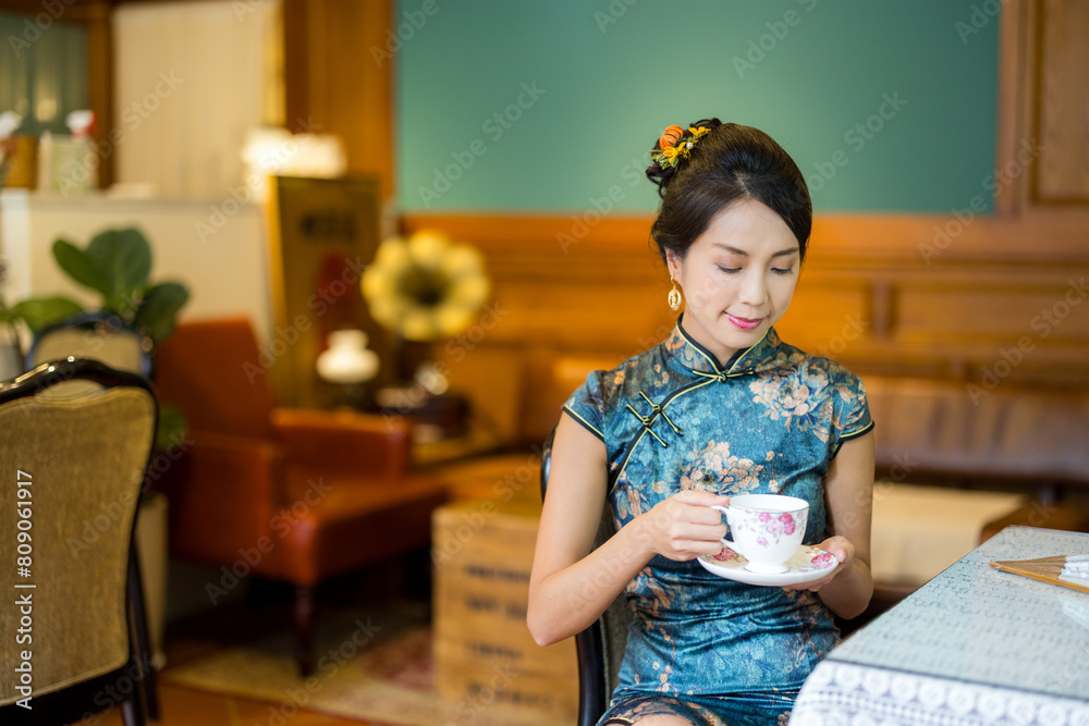 Canvas Prints woman wear traditional chinese cheongsam and enjoy cup of tea in the vintage restaurant