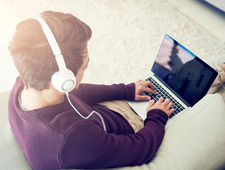 Man, laptop and music on sofa in home with top view for audio streaming, subscription service and...
