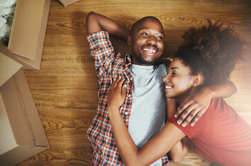 Relax, hug and happy couple on floor in new home with boxes, laugh and mortgage with high angle....