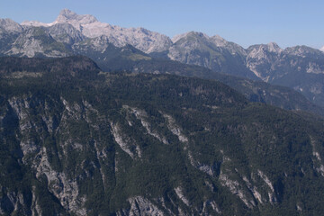 Close-up photo of the mountain peaks and the slopes of the mountains overgrown with trees in...