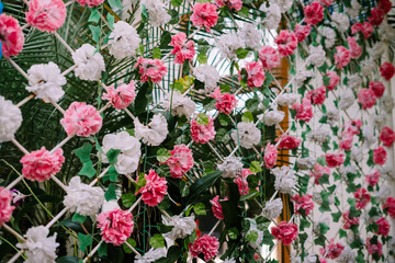 Artificial flowers crafted from plastic, adorning a wall as decorative elements, offering...