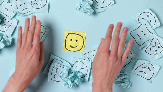 Sad faces on blue stickers and one yellow happy one. Positive sticker, smile sign on background of sad symbols. Concept of success and winning in business.