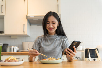 Asian Girl  eating Thai food in kitchen counter Home delivery food feeling happy 
