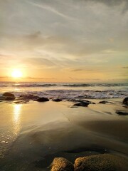 Yellow-orange sunset and sunrise on the ocean shore, Bali island. Epic sunrise, sandy beach. Landscape of Indonesia