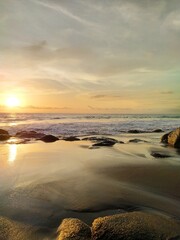 Yellow-orange sunset and sunrise on the ocean shore, Bali island. Epic sunrise, sandy beach. Landscape of Indonesia