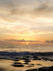 Naklejka premium Yellow-orange sunset and sunrise on the ocean shore, Bali island. Epic sunrise, sandy beach. Landscape of Indonesia