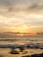 Obraz premium Yellow-orange sunset and sunrise on the ocean shore, Bali island. Epic sunrise, sandy beach. Landscape of Indonesia