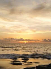 Yellow-orange sunset and sunrise on the ocean shore, Bali island. Epic sunrise, sandy beach. Landscape of Indonesia