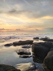 Fototapeta premium Yellow-orange sunset and sunrise on the ocean shore, Bali island. Epic sunrise, sandy beach. Landscape of Indonesia