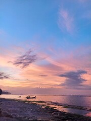 Epic dramatic sunset, sunrise over the ocean, red-orange sky with clouds, sun and sunlight. Island of Bali, Indonesia