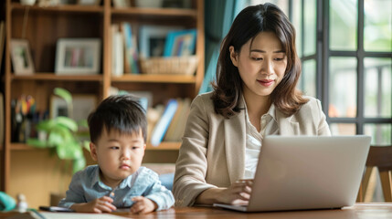 Asian Businesswoman Mom Working On Her Laptop In Her Home With Her Son