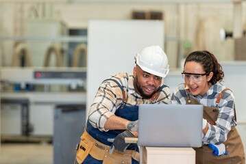 Two colleague young aged carpenter standing aim equipment tool for wood furniture at wood plank in workshop. coworker carpenter working craft with wood diy tool in workbench shop carpentry