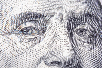 Macro image of eyes of Benjamin Franklin on the one hundred US Dollar bill.