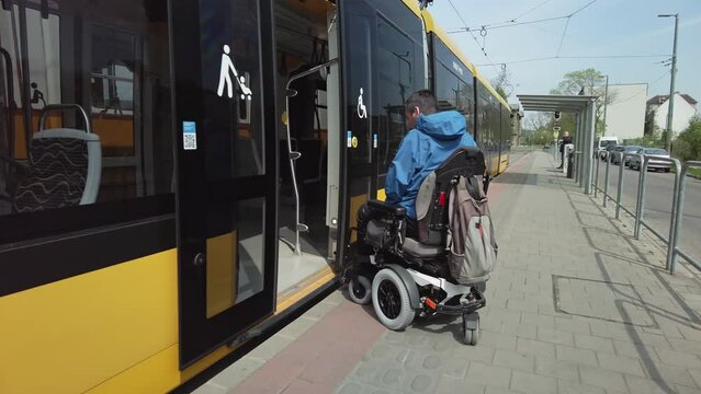 Man on wheelchair getting on the train, accessible public transport, tracking shot. Independent lifestyles concept.