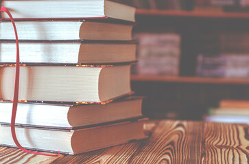 Book stack in the library room and blurred bookshelf for business and education background
