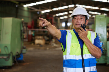 senior worker talking on walkie talkie in the factory
