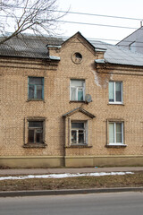 Obraz premium Brick building with tree in front, showcasing classic facade and wooden fixture