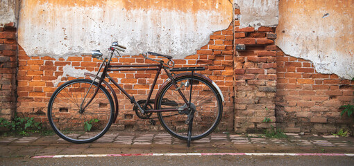 Vintage bicycle on old rustic dirty wall house, many stain on wood wall. Classic bike old bicycle...