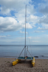 Catamaran with mast on the lake shore.