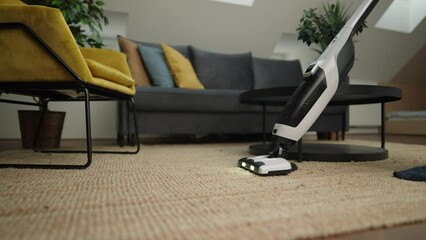 Medium shot - Cleaning service in airbnb, unrecognisable person vacuuming a jute rug in an apartment