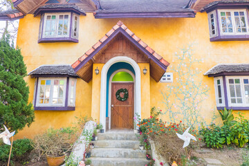 Fototapeta premium Wooden door of Yellow house with Christmas wreath.