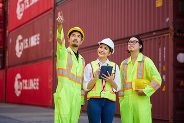 workers working on tablet for checking product and pointing at containers warehouse storage