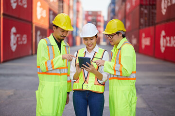 workers working on tablet for checking product in containers warehouse storage