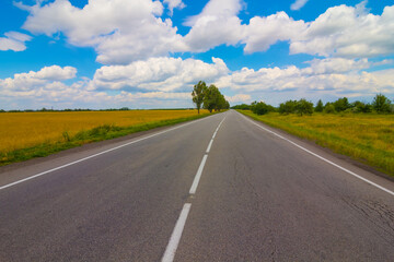 long asphat road under a cloudy sky, summer transportation scene