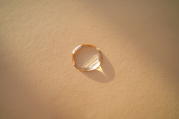 Beautiful volumetric drop of cosmetic product on a beige background.