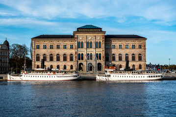National Museum of Fine Arts (Nationalmuseum) building located on peninsula Blasieholmen in city centre with white boats, ships on Lake Malaren water, blue sky background, Stockholm, Sweden
