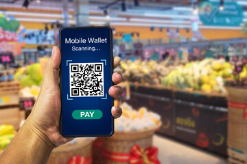 Mobile wallet payment with qr code concept. Hands holding mobile phone on blurred fruit zone as...