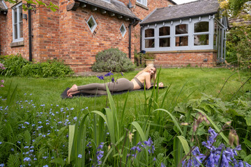 Woman practicing yoga in a garden