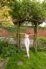 Woman practicing yoga in a garden