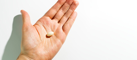 Design Progesterone Pill, Capsules In Human Hand On White Background. Dose Of Medications Treats Irregular Menstrual Cycle, Fertility Treatments, Menopausal Hormone Therapy, Horizontal Copy Space