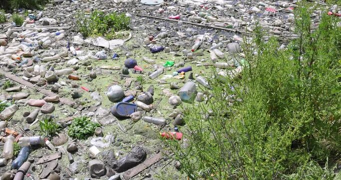 Polluted river with plastic bottles, garbage and various waste floating on the surface, pollution and environmental contamination