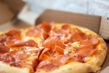 Pizza with pepperoni in a cardboard box, a staple fast food dish